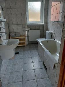 ein Badezimmer mit einer Badewanne und einem Waschbecken in der Unterkunft Willa KaMa in Szklarska Poręba