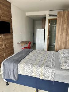 a bedroom with a bed and a refrigerator at Flat com localização privilegiada in Campina Grande