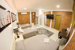 una camera con due letti e un muro di mattoni di HOTEL OBREGON a Iguala de la Independencia