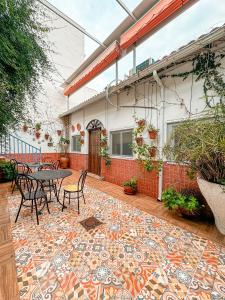 eine Terrasse mit einem Tisch und Stühlen auf einem Fliesenboden in der Unterkunft Casa Cruz in Almodóvar del Río