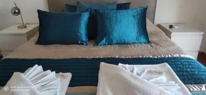 ein Bett mit blauen und weißen Kissen darauf in der Unterkunft AL "Villa Por Do Sol" Sunset Olhão in Olhão