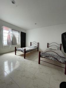 two beds in a room with a window at CASA EN FLANDES A 10 MIN DE GIRARDOT in Flandes