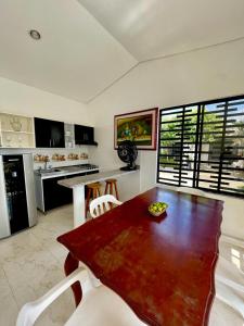 a kitchen with a wooden table and white chairs at CASA EN FLANDES A 10 MIN DE GIRARDOT in Flandes