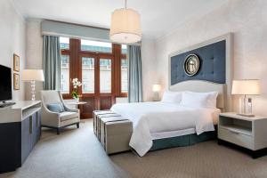 a bedroom with a large white bed and a chair at Hotel Bristol, A Luxury Collection Hotel, Warsaw in Warsaw