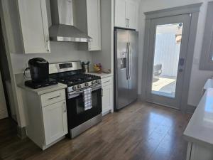 a kitchen with a stove and a refrigerator at Entire home in Historic Long Beach close to shops in Long Beach