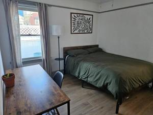 a bedroom with a bed and a table and a window at Entire home in Historic Long Beach close to shops in Long Beach