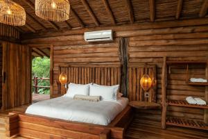 a bedroom with a bed in a log cabin at Hotel Boutique Maitta en Doradal Antioquia in Doradal