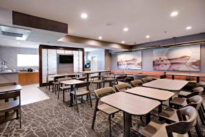 a restaurant with tables and chairs and a kitchen at SpringHill Suites Phoenix Glendale/Peoria in Peoria