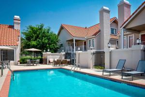a swimming pool in front of a house at Residence Inn Dallas Las Colinas in Irving