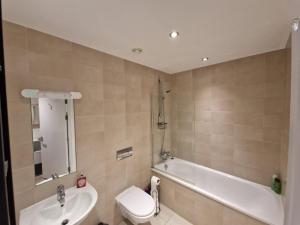 a bathroom with a sink and a tub and a toilet at Luxury Modern Apartment Stay in Sheffield