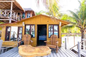a cabin with two chairs and a table on a deck at Grand Titanic, Boat House in Punta Allen +12 photos