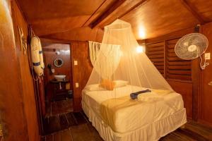 a bedroom with a bed with a net on it at Grand Titanic, Boat House in Punta Allen