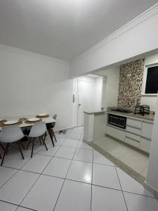 una cucina con tavolo, sedie e piano cottura di Apartamento em Santos no Gonzaga em frente a praia a Santos
