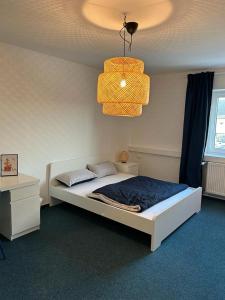 a bedroom with a bed and a chandelier at 4rooms - Bamberger Gemütlichkeit in Bamberg