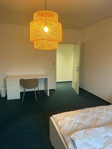 a bedroom with a bed and a desk and a chandelier at 4rooms - Bamberger Gemütlichkeit in Bamberg