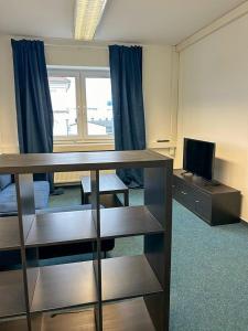 a room with a desk with a television and a room with a window at 4rooms - Bamberger Gemütlichkeit in Bamberg