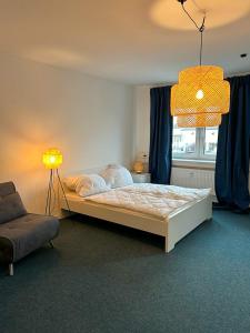 ein Schlafzimmer mit einem Bett, einer Lampe und einem Stuhl in der Unterkunft 4rooms - Bamberger Gemütlichkeit in Bamberg