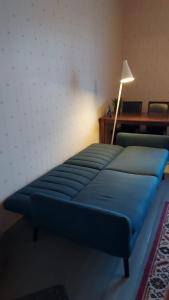 uma cama azul num quarto com um candeeiro em Entisajan Helmi em Tampere