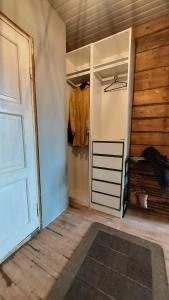 a room with a closet with a door and a rug at Entisajan Helmi in Tampere