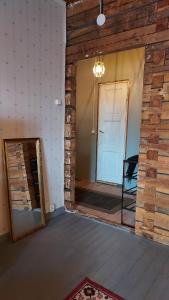a room with a brick wall and a doorway with a mirror at Entisajan Helmi in Tampere