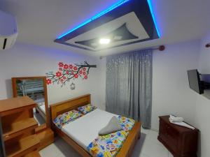 a bedroom with a bed with a blue light on the ceiling at Villa Kerly Hotel en La Unión Valle in Lemos