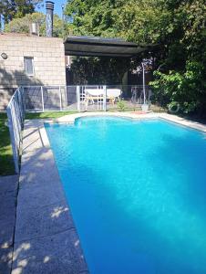 einen Pool mit blauem Wasser im Hof in der Unterkunft Don Vicente in Villa Leloir