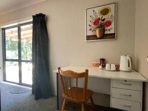 a desk with a chair and a picture of a sunflower at Self checkin master room with private bathroom in Hamilton