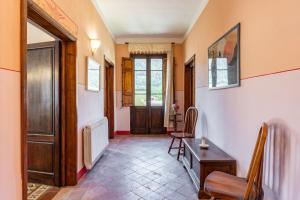 un couloir avec une porte, une table et des chaises dans l'établissement Appartamento in villa liberty, à Ghivizzano