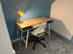 a desk with a chair and a desk with a lamp at Modern 3 Bedroom House, Sleeps 6 - Free Parking & Garden - Opposite Racecourse, Near City Centre & Hospital in Doncaster