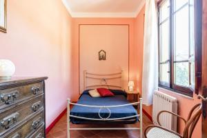 - une petite chambre avec un lit et une commode dans l'établissement Appartamento in villa liberty, à Ghivizzano