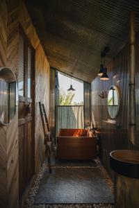 a bathroom with a large tub and a sink at STAY PILAFarm in Ban Nam Chun Yai