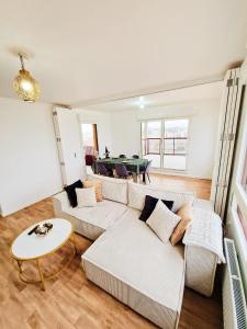 uma sala de estar com um sofá e uma mesa em CHARMING APARTMENT WITH PANORAMIC SEINE RIVER & EIFFEL TOWER VIEWs em Ivry-sur-Seine