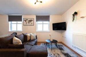 a living room with a couch and a table at Jasper- 2 Bed Flat With Parking in Southampton