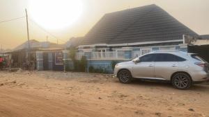 a white car parked in front of a house at De Emeritus Courtyard in Kubwa