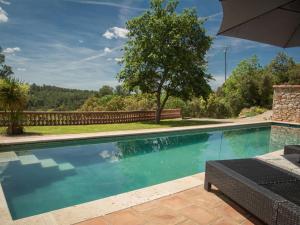 einen Pool im Garten mit Sonnenschirm in der Unterkunft La Bastide Romaine in Entrecasteaux
