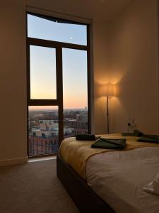 una camera da letto con una grande finestra con vista sulla città di Cozy Room with Private Bathroom in Luxurious Flat a Londra