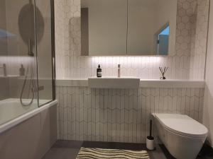 Cozy Room with Private Bathroom in Luxurious Flat في لندن: حمام مع مرحاض ومغسلة وحوض استحمام