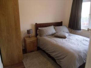 a bedroom with a bed and a lamp on a night stand at House in Great Barr, with parking and garden in Birmingham