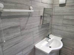 a white bathroom with a sink and a mirror at House in Great Barr, with parking and garden in Birmingham