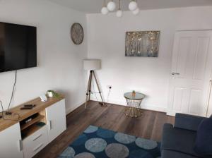a living room with a tv and a blue couch at House in Great Barr, with parking and garden in Birmingham