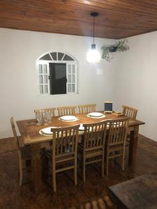 comedor con mesa de madera y sillas en Casa de Família com Ar Condicionado, Garagem e Pet friendly, en Búzios
