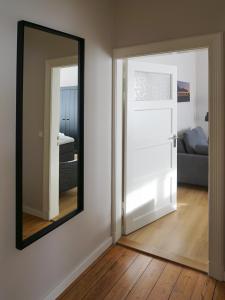 a mirror on a wall next to a living room at Mollibahnhof - Kühlungsborn West Mollibahnhof West - Ferienwohnung 01 in Kühlungsborn