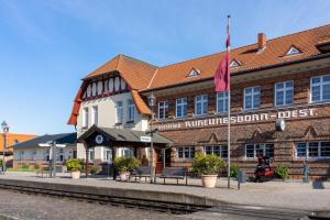 a train station with a building with a flag at Mollibahnhof - Kühlungsborn West Mollibahnhof West - Ferienwohnung in Kühlungsborn