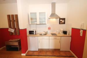 a small kitchen with a sink and a microwave at Mollibahnhof - Kühlungsborn Ost Mollibahnhof Ost - Ferienwohnung 01 in Kühlungsborn