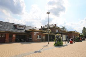 a large brick building with people sitting outside of it at Mollibahnhof - Kühlungsborn Ost Mollibahnhof Ost - Ferienwohnung 01 in Kühlungsborn