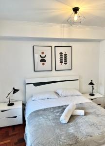 een slaapkamer met een groot wit bed met 2 lampen bij Cantinho do Castelo in Bragança