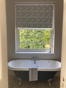 a bath tub in a bathroom with a window at North Clifton Hall in North Clifton