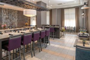 a restaurant with a long bar with purple chairs at SpringHill Suites Seattle Downtown in Seattle