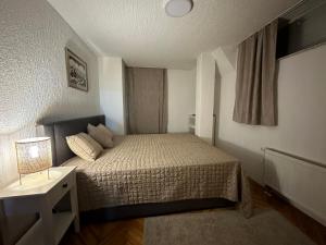 - une petite chambre avec un lit et une lampe dans l'établissement Vila Forino, à Vogošća