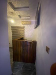 a room with a wooden cabinet and a wall at De Emeritus Courtyard in Kubwa